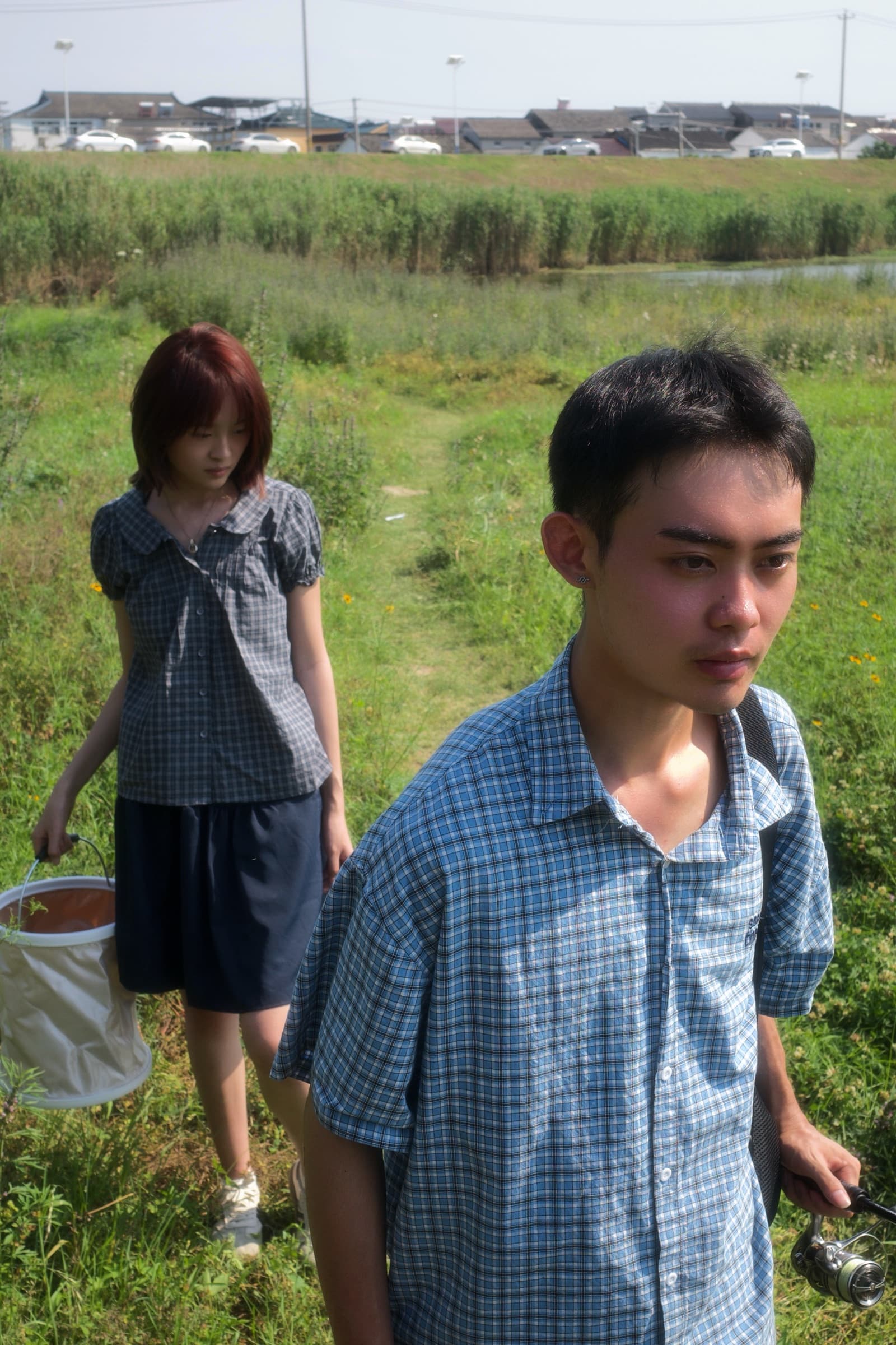 乡野场景中两位人物的纵向摄影作品